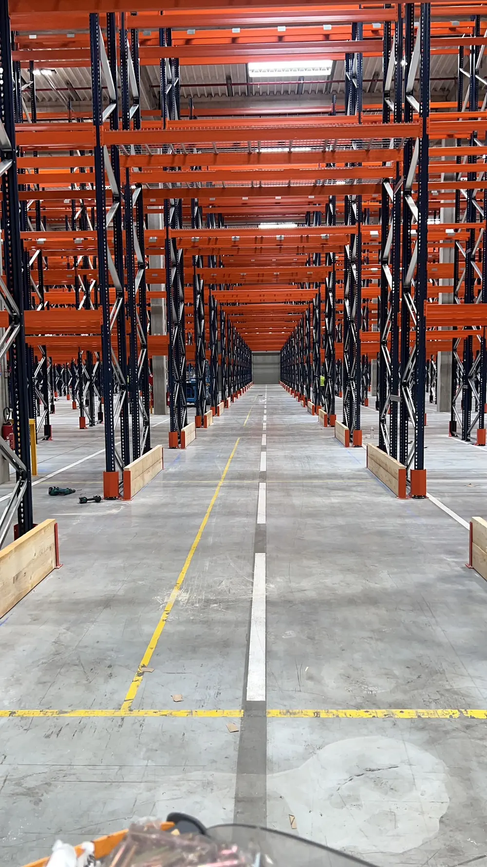 Allée de rack à palettes grande hauteur, lisses orange sur plusieurs niveaux