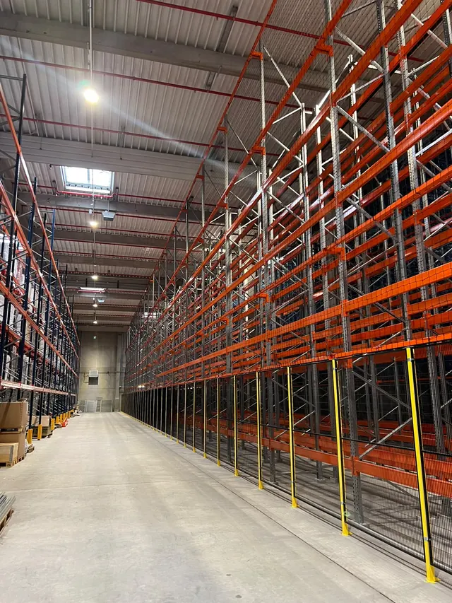 Rack à palettes grande hauteur monté en double rangée le long d'une allée de circulation