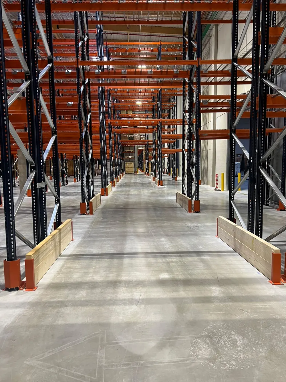 Allée de rack à palettes avec protections de pied et sabots d'échelle