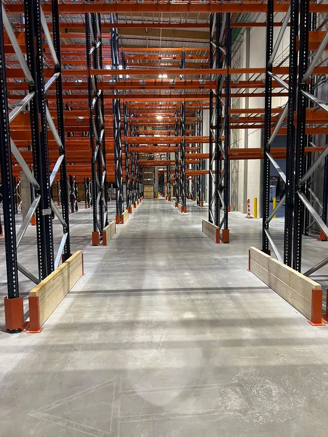 Allée de rack à palettes avec protections de pied et sabots d'échelle