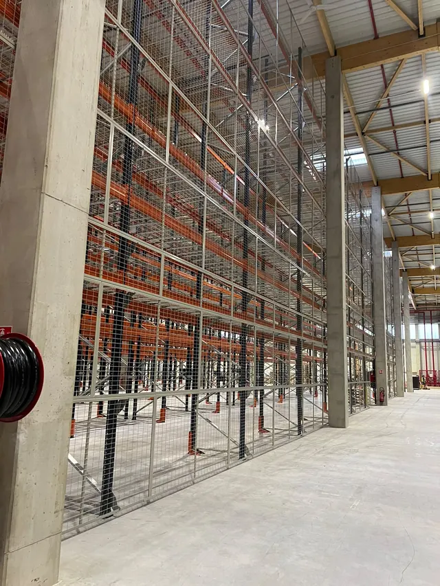 Rack à palettes équipé de grillage anti-chute de charges en fond de travée