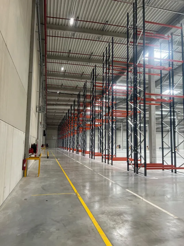 Allée de rack à palettes le long d'un mur béton, marquage au sol réalisé