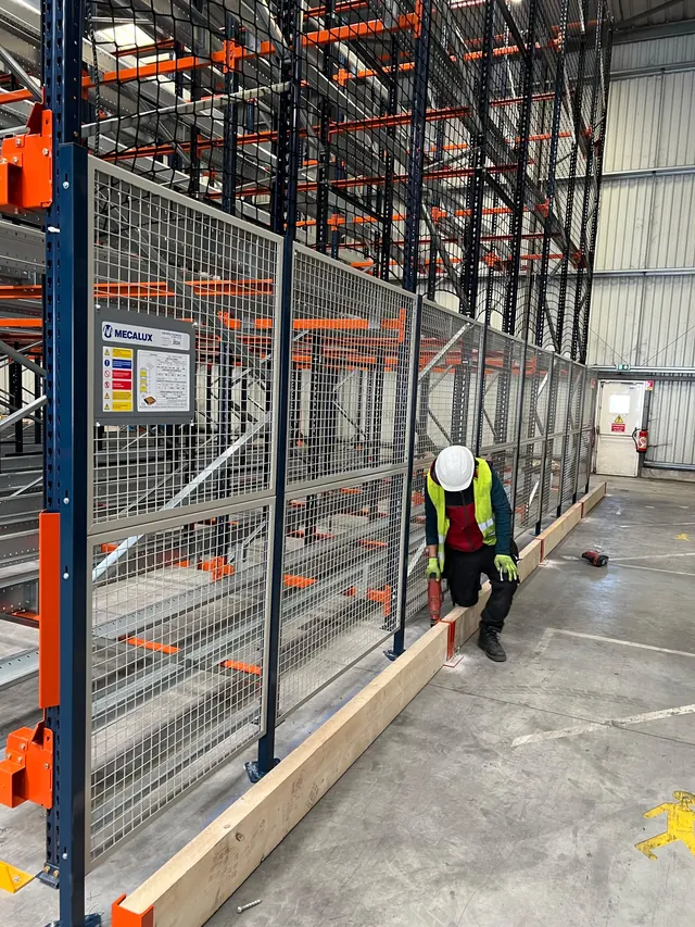 Grillage de sécurité posé en fond de rack à palettes par un monteur équipé
